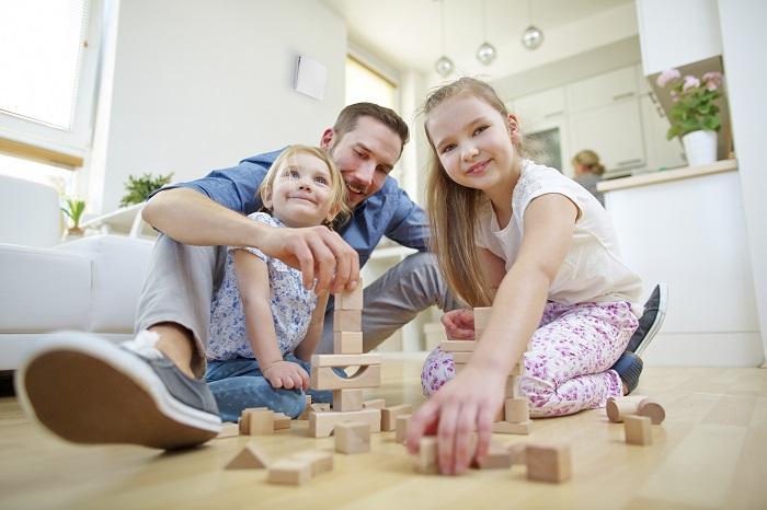 Vater und Kinder spielen mit Bausteinen